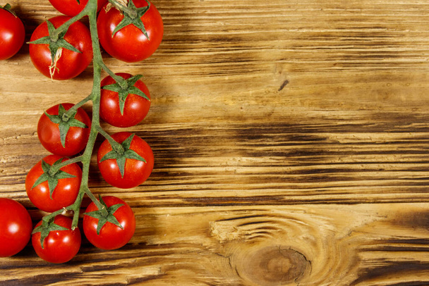 Fresh cherry tomatoes on a wooden table. Top view - Fotó, kép