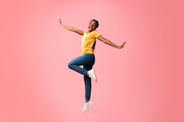 femme heureuse sautant dans l'air posant sur fond rose studio
 - Photo, image