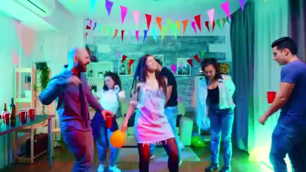 Přiblížit záběr krásné kavkazské tance se svými přáteli na párty s neonovými světly - Záběry, video