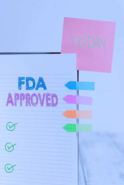 Writing note showing Fda Approved. Business photo showcasing FDA agreed the product or formula is safe and or effective Hard cover note book sticky note arrow banner inserted clear background. - Photo, Image