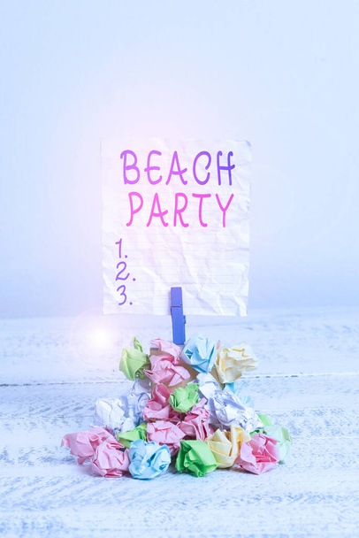 Textschild mit Beachparty. Konzeptfoto große Gruppe von Shows organisieren eine Veranstaltung am Strand Erinnerungsstapel farbig zerknittertes Papier Wäscheklammer Erinnerung weißen Holzraum. - Foto, Bild