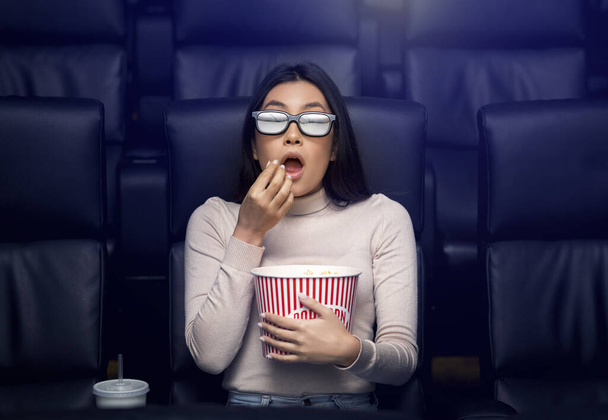 Going to movies alone. Scared Asian woman in 3D glasses watching thriller in cinema - Fotoğraf, Görsel