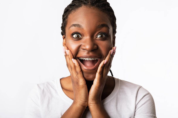 Innoissaan tyttö hammasraudat huutaa jännitystä valkoisella taustalla
 - Valokuva, kuva