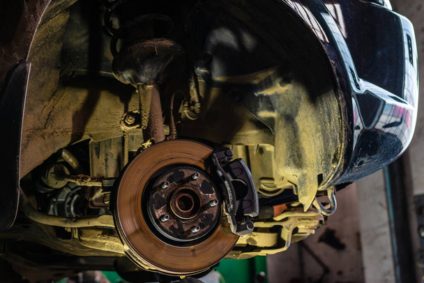 Car brake disc closeup on car service lifted for replacement 2020 - Photo, Image
