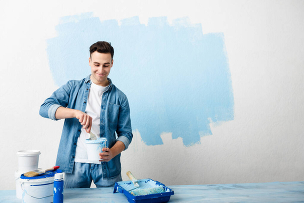 Happy guy mixes pigment for paint wall - Foto, Bild