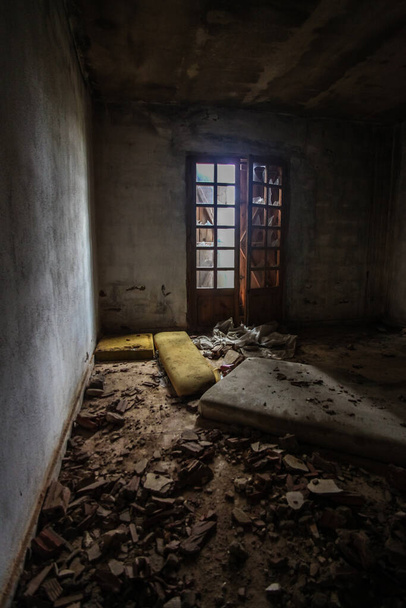 Εγκαταλελειμμένο και βρώμικο μέρος με πόρτα στην εξοχή με σπασμένα γυαλιά - Φωτογραφία, εικόνα