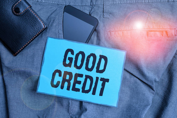 Handwriting text writing Good Credit. Concept meaning borrower has a relatively high credit score and safe credit risk Smartphone device inside trousers front pocket with wallet and note paper. - Photo, Image