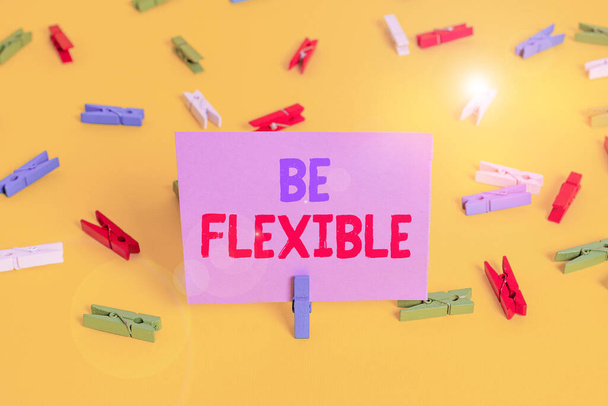 Handwriting text writing Be Flexible. Concept meaning able to be easily modified to respond to altered circumstances Colored clothespin papers empty reminder yellow floor background office. - Photo, Image