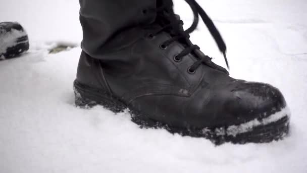 Prosty kąt człowieka w bojowych butach potężnie stąpającego po śniegu w zwolnionym tempie - żołnierz, wojsko, wojna, przemoc - Materiał filmowy, wideo
