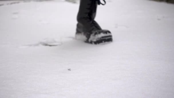 Widok z przodu potężnego żołnierza w bojowych butach potężnie stąpającego po śniegu w zwolnionym tempie - żołnierz, wojsko, wojna, przemoc - Materiał filmowy, wideo