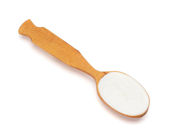 Yogur líquido en una cuchara de madera
 - Foto, Imagen