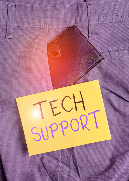Writing note showing Tech Support. Business photo showcasing advising and troubleshooting service provided by a manufacturer Small wallet inside trouser front pocket near notation paper. - Photo, Image