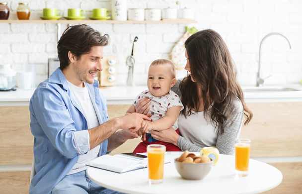 Millennial parents working at kitchen with baby - Foto, Bild