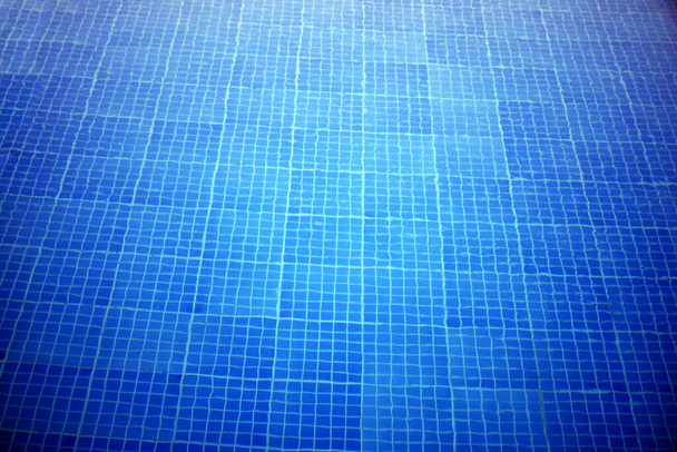 Modré dlaždice na dně bazénu s vodou.Krásná studená voda v mozaikovém dně bazénu.Textura dno bazénu. - Fotografie, Obrázek