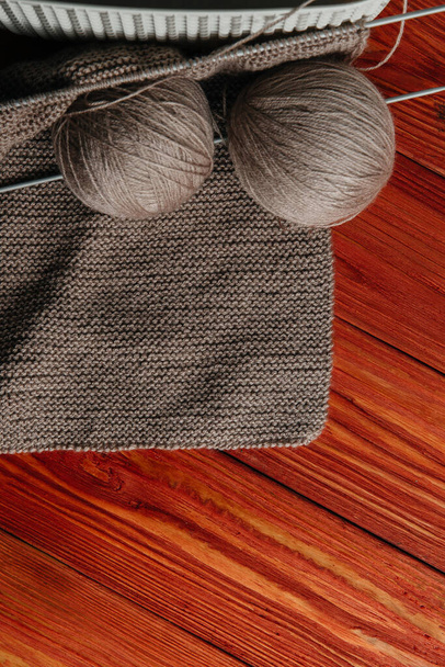 Agulha de inverno. Bolas de fios de lã para tricô manual e raios de tricô em um fundo de madeira. Espaço de texto Layout plano, plano grande, vista superior, cópia do espaço
 - Foto, Imagem
