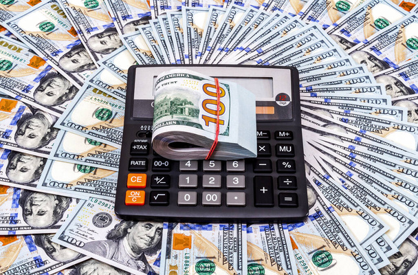 Calculadora y billetes de dólares en el fondo del dinero
 - Foto, Imagen