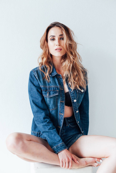 Portrait of a beautiful fashionable woman in street style denim shorts - Photo, Image