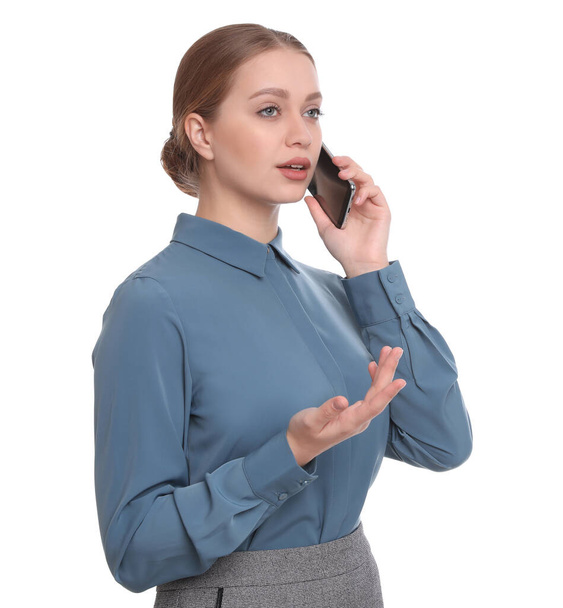 Young businesswoman talking on mobile phone against white background - Фото, изображение