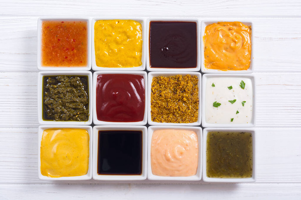 Set of different sauces in ceramic bowl on rustic background - Photo, image