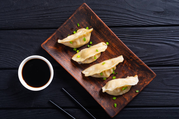 Traditional asian dumplings gyoza with green onion and soy sauce - Foto, afbeelding