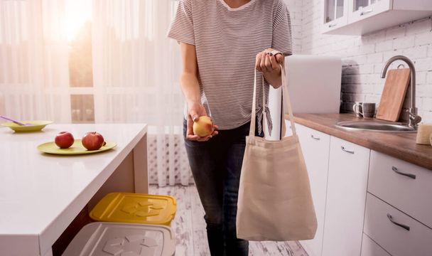 Young girl holding a cloth bag. At the kitchen. I am not plastic.  - Foto, Imagen