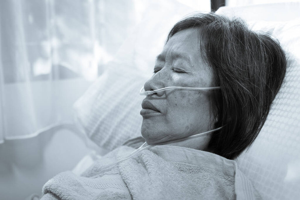 Egy idős ázsiai beteget, akinek vírusos tüdőgyulladása volt, oxigénkanüllel kezeltek a kórházban. - Fotó, kép