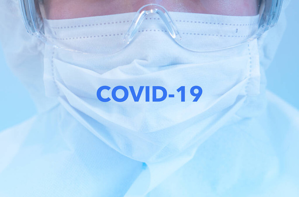 A doctor wearing personal protective equipment including mask, goggle, and suit to protect COVID 19 infection - Fotografie, Obrázek
