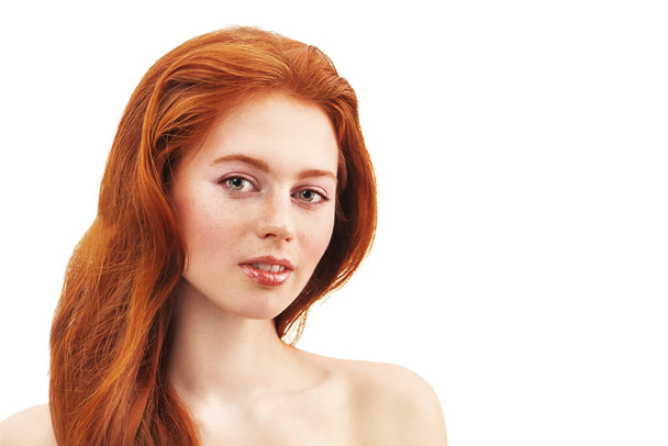 Egy gyönyörű fiatal nő portréja, gyönyörű vörös hajjal, szeplőkkel az arcán. Szépség és bőrápolás. - Fotó, kép