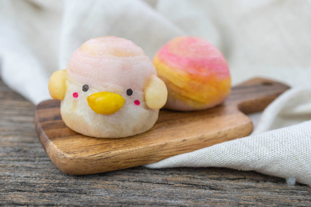 Cute Chinese Pastry or moon cake stuffed with salted egg yolk on wood plate - Photo, Image