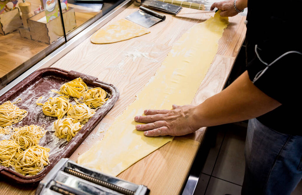 Chef rolling dough with a pasta machine. Pasta maker machine. Hom - Foto, Bild