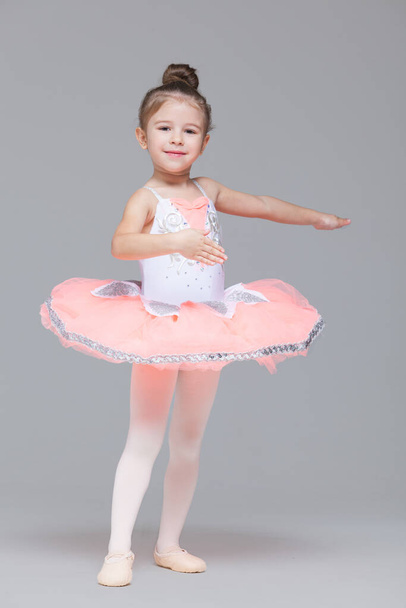 Cute adorable ballerina little girl in pink tutu dance practices ballet dancing - Foto, Bild