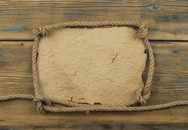 aged paper with rope frame on old wood background - Photo, Image