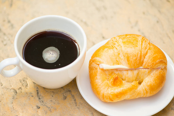 白いカップと黒のコーヒーとクロワッサンチーズ  - 写真・画像