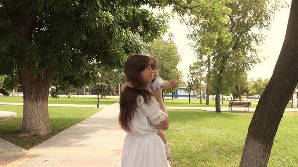 Beautiful mother carries a little daughter in the park in open air. Beautiful mother and her baby are playing in park. baby and hugs happy mother. Happy Mothers Day Joy. Mom and baby. 4K - Φωτογραφία, εικόνα