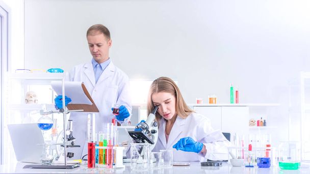 Two scientists researching for some confidential in chemical laboratory, teamwork and scientist working concept - Photo, image
