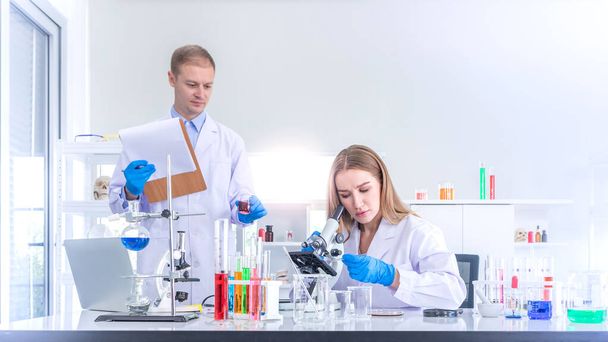 Two scientists researching for some confidential in chemical laboratory, teamwork and scientist working concept - Foto, Imagem