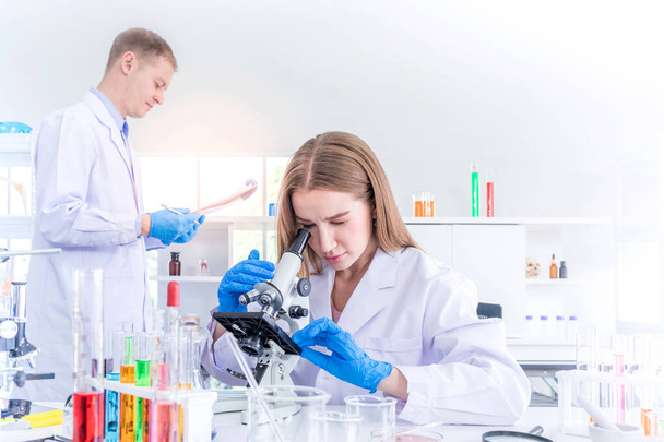 Two scientists researching for some confidential in chemical laboratory, teamwork and scientist working concept - Photo, Image