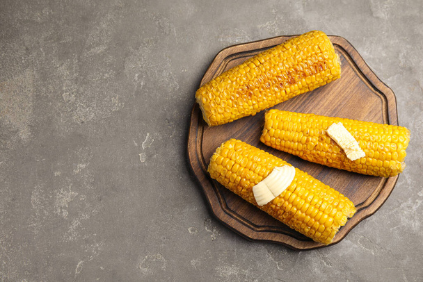 Delicious grilled corn with butter on grey table, top view. Space for text - Foto, Imagem