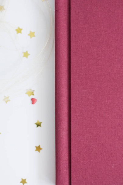 Doek marsala boek of album voor foto 's met decoraties van lint en goud confetti - Foto, afbeelding