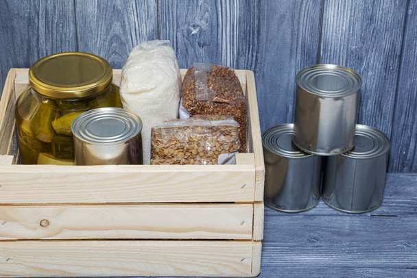 canned food and various cereals on a wooden shelf, food crisis - Foto, Imagem