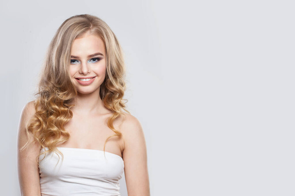 Atraktivní žena módní model s blond vlasy s úsměvem na bílém pozadí - Fotografie, Obrázek