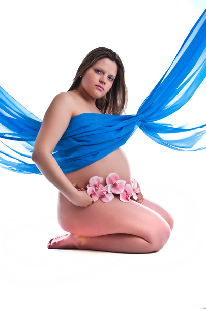 Schwangere junge Frau in Stoff mit Orchidee - Foto, Bild