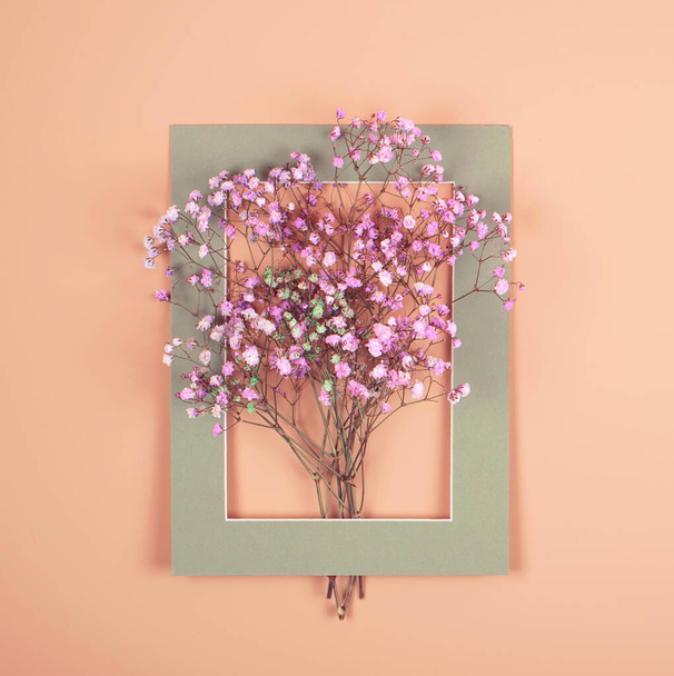 Tender photo. A small bouquet in a frame on a beige background. Holiday photo. - Photo, Image