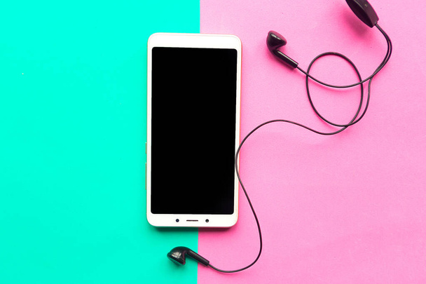 Mockup κινητό και ακουστικά σε γεωμετρικό χρώμα φόντο. Ελάχιστη έννοια - Φωτογραφία, εικόνα