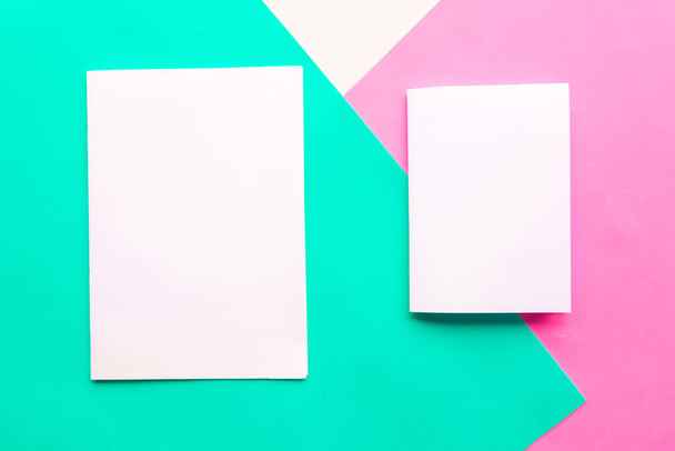 Dos maquetas blancas en blanco sobre fondo geométrico verde, rosa y blanco. Copia espacio para el texto. Concepto mínimo
 - Foto, Imagen