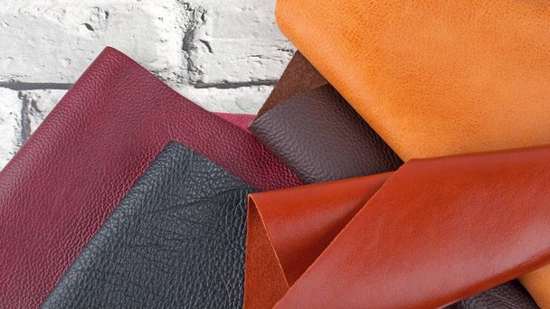 Different colors natural leather textures samples on grey brick background - Fotoğraf, Görsel
