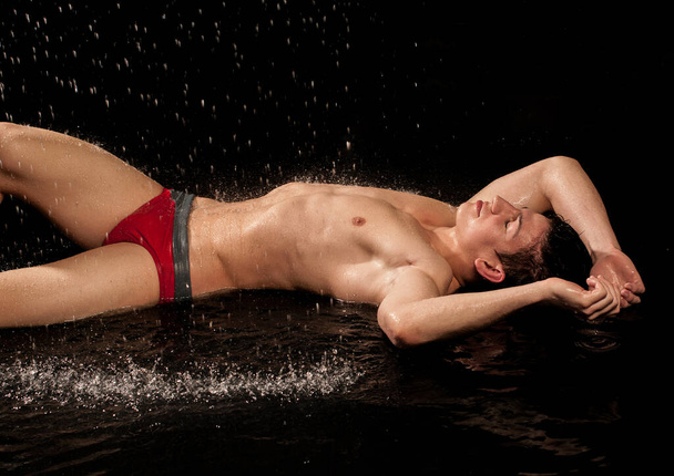 Gespierd mannelijk model met waterdruppels - Foto, afbeelding