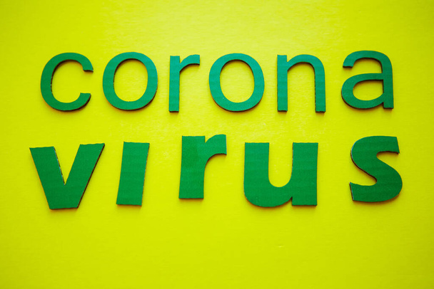 Word CORONAVIRUS made of green cardboard letters, isolated on yellow background. World Health Organization WHO introduced new official name for Coronavirus disease named COVID-19. - Fotó, kép