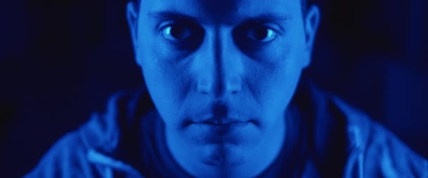 Portrait of a young man putting on a protective mask. Concept of health and safety life, virus protection, pandemic. Close up, slow motion, blue lighting. BMPCC 4K - Filmagem, Vídeo