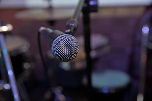 Professional condenser studio microphone, Musical Concept. recording, selective focus microphone in radio studio, selective focus microphone and blur musical equipment guitar,bass,drum piano - Photo, Image